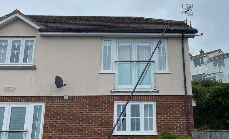 windows on side of house with pole going to guttering