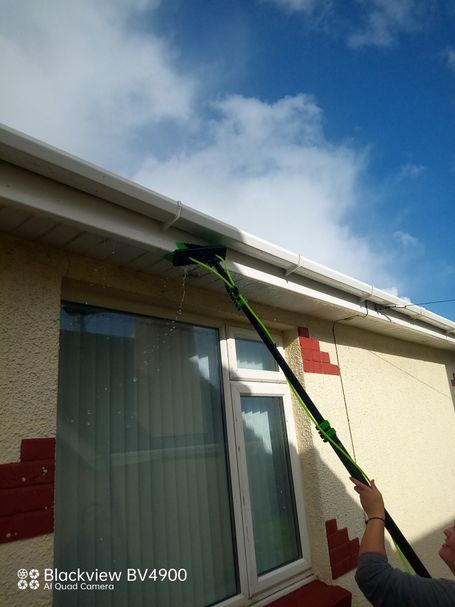 brush washing gutter and fascia on bungalow